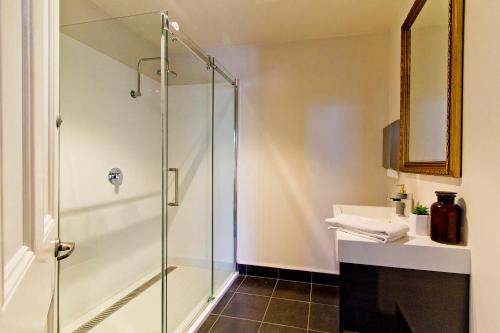 a bathroom with a glass shower stall and a sink at Deloraine Hotel in Deloraine