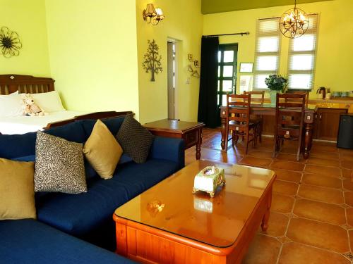 a living room with a blue couch and a table at 台東鹿野森活 訂房來電付訂確認 in Ruiyuan