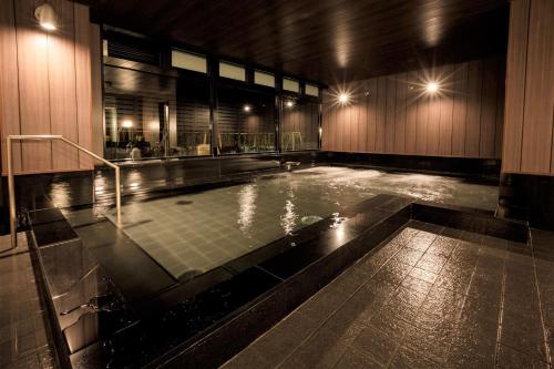 a swimming pool in a building at night at S-peria Hotel Kyoto in Kyoto