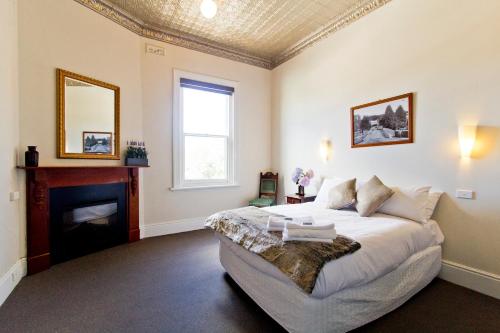 a bedroom with a bed and a fireplace at Deloraine Hotel in Deloraine