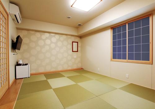 a room with a large window and a tiled floor at Arigato Stay Kanazawa Katamachi in Kanazawa