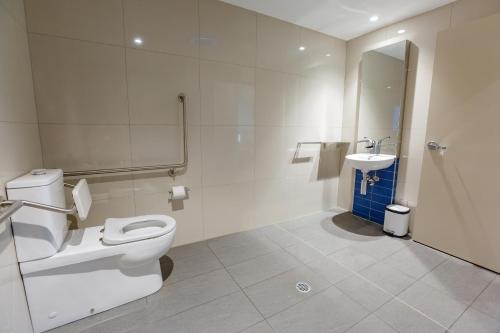 La salle de bains est pourvue de toilettes et d'un lavabo. dans l'établissement Global Backpackers Cairns, à Cairns