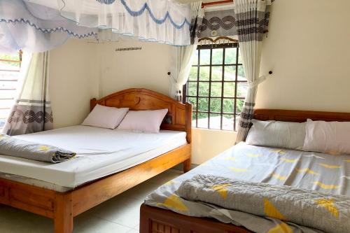 a bedroom with two beds and a window at Tám Thọ homestay in Tân Hiệp