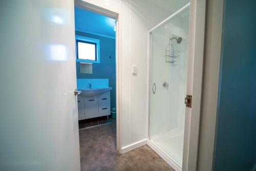 a bathroom with a shower and a sink at Coronation Park Motels in Ashburton