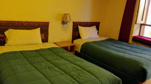 two beds sitting next to each other in a room at B&B Chayana Wasi in Ollantaytambo