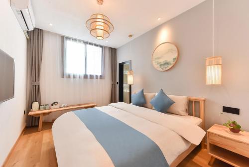 a bedroom with a large bed with blue pillows at Yifangyan - Tingyuan Qingshe Hostel in Fenghuang
