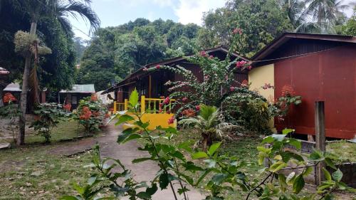 a small house with a red and yellow at Johans Chalet in Tioman Island