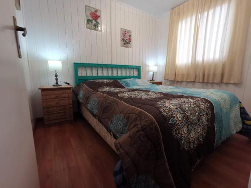 a bedroom with a bed with a green head board at Casas Isla Negra in El Quisco