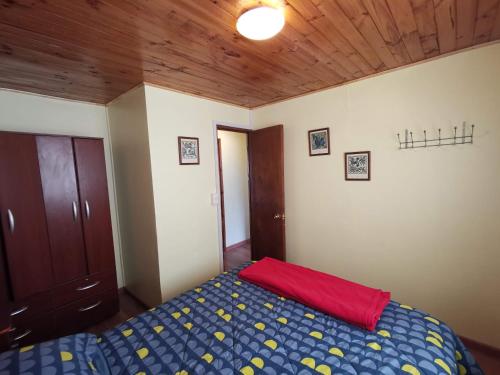 a bedroom with a bed and a wooden ceiling at Casas Isla Negra in El Quisco