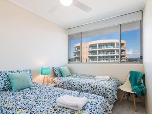 a bedroom with two beds and a large window at Oceanic 26 in Forster