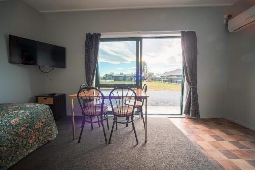 a room with a table and chairs and a window at Coronation Park Holiday Park in Ashburton