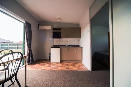 a small kitchen with a table and a bed in a room at Coronation Park Holiday Park in Ashburton
