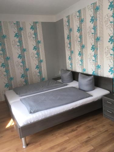 Bett in einem Zimmer mit einer Wand in der Unterkunft Pension Sonntag in Ingolstadt