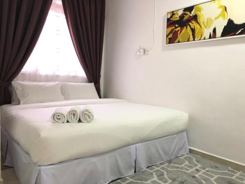 Una habitación de hotel con una cama con dos toallas. en Terengganu Guest House, en Kuala Terengganu