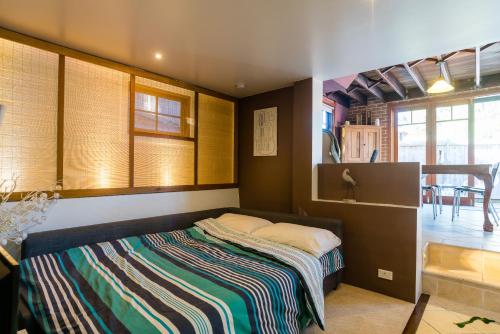 una camera da letto con un letto con una coperta a righe di 5 Stars Sydney City & Airport Retreat a Sydney