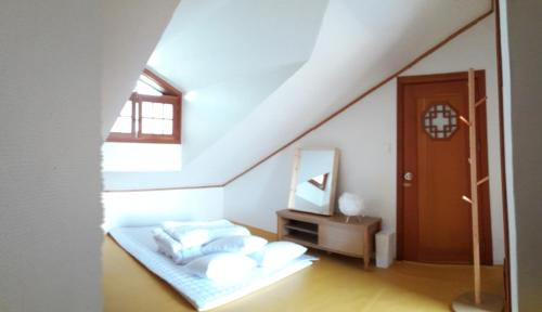 a attic bedroom with a bed and a mirror at BluePlanet in Gyeongju