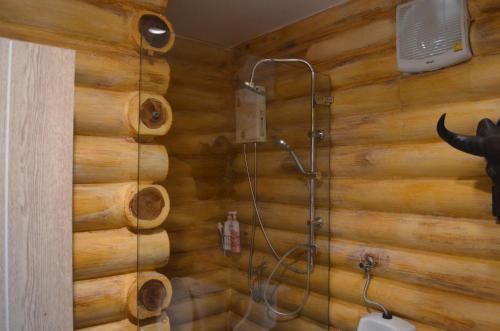 a bathroom with a shower in a wooden wall at WIND of LOVE in Ban Tha Chang