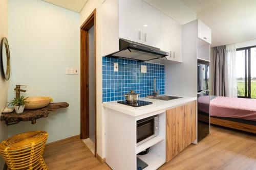 eine kleine Küche mit einem Waschbecken und einem Bett in der Unterkunft Mimi House in Hoi An