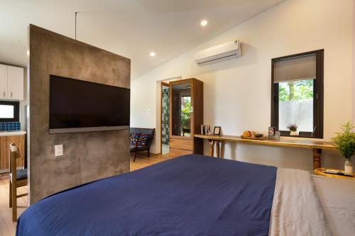 a bedroom with a large bed and a flat screen tv at Mimi House in Hoi An