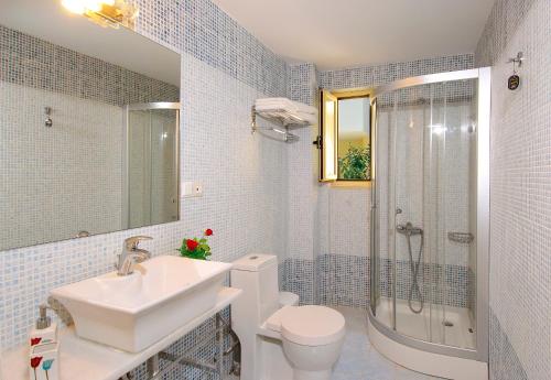 een badkamer met een wastafel, een toilet en een douche bij Lissos Beach in Plataniás