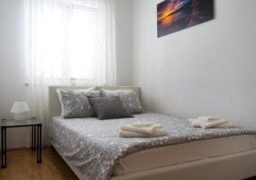a bedroom with a bed with two towels on it at Apartment Rose in Korčula