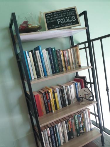 a book shelf filled with books in a room at ACERO ROSSO in Pianfei
