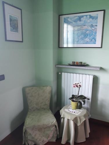 a room with a chair and a table with a plant at ACERO ROSSO in Pianfei