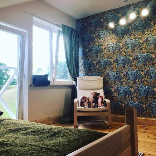 a bedroom with two dogs sitting in a chair at ALANTOS ŽIRGAI Holiday Villas sauna or hottube additional price in Alanta