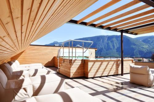 a balcony with white furniture and a view of mountains at Apparthotel Gartenresidence Nalserhof in Nalles