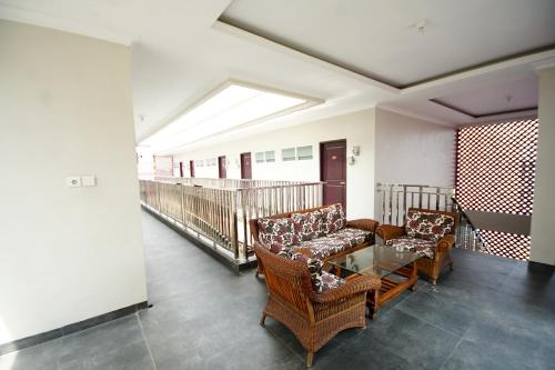 a living room with two chairs and a glass table at Super OYO 270 Madinah Residence Syariah in Talang Kelapa