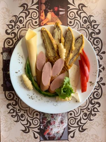 ネセバルにあるElizabeth Dy Boutique Hotelのテーブルの上に置かれた肉と野菜の料理の皿