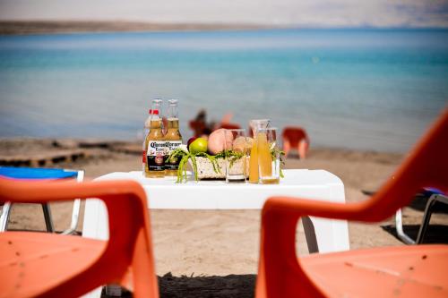 a table topped with a glass of orange juice and a surfboard at Biankini Village Resort in Kalia