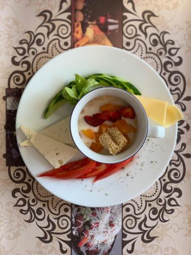 ネセバルにあるElizabeth Dy Boutique Hotelのスープと野菜が入った白い皿