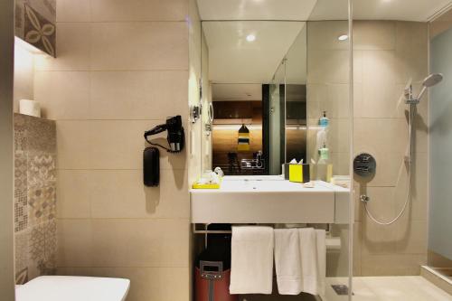 a bathroom with a sink and a toilet and a shower at Radisson Bengaluru City Center in Bengaluru