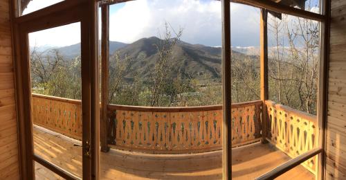 a view from the porch of a cabin with a large window at Verin Tun in Dilijan