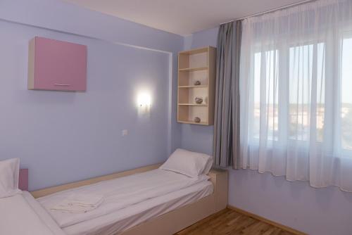 a small room with two beds and a window at Hiora Apartments Vasiliko in Tsarevo