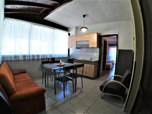 cocina y sala de estar con mesa y sillas en Pension Karvounoskala, en Stratoni