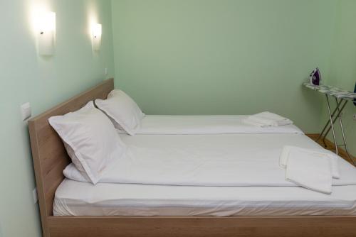 two beds in a room with white sheets and pillows at Hiora Apartments Vasiliko in Tsarevo