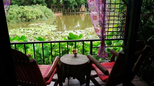 a table with chairs and flowers on it at Saikaew Resort in Chiang Rai