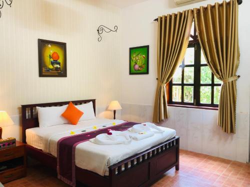 ein Schlafzimmer mit einem Bett mit Handtüchern darauf in der Unterkunft Mango Home Riverside in Ben Tre