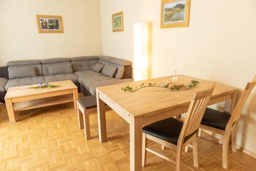 a living room with a table and a couch at Hotel und Berggasthof Tanzbuche in Friedrichroda
