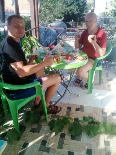 two older men sitting at a table eating food at My home udabno in Udabno