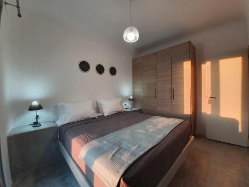 a bedroom with a large bed with a wooden cabinet at Villa Therme Athena in Emporio Santorini