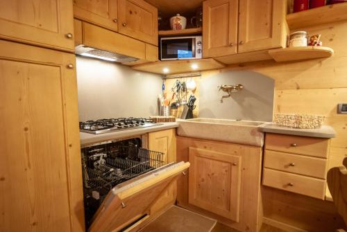 a kitchen with wooden cabinets and a stove top oven at Mountain Loft in Tarvisio