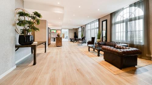 uma sala de estar com um sofá e uma mesa em Hotel Acropolis " Op het sportiefste park van de kust " em Middelkerke