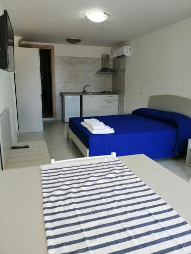 a room with two beds and a blue bed at Monolocale Tirreno studio seafront in Formia
