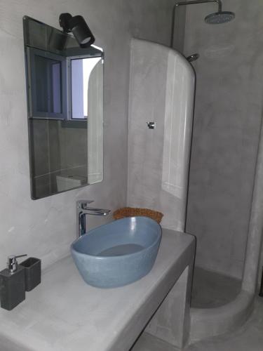 W łazience znajduje się niebieska umywalka i lustro. w obiekcie Villa Therme Athena w mieście Emporio