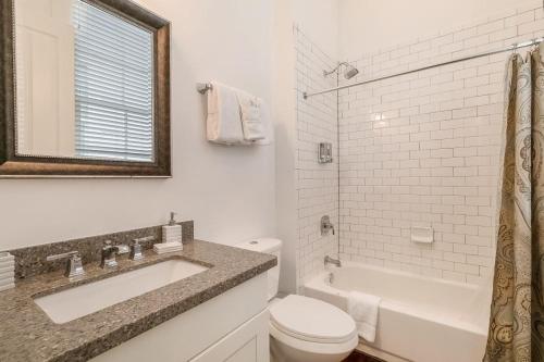 a white bathroom with a sink and a toilet at Fabulous Cottages with City Views in New Orleans