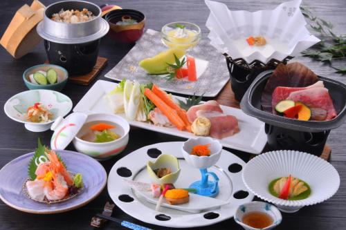a table with plates of food and bowls of food at Mashikokan Satoyama Resort Hotel in Mashiko