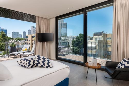 sypialnia z łóżkiem i dużym oknem w obiekcie master Shenkin w Tel Awiwie
